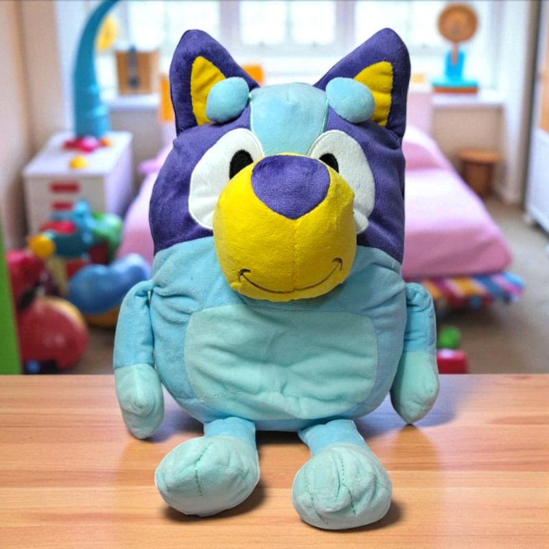 Bluey Plush toy with purple ears and yellow muzzle on a wooden surface.