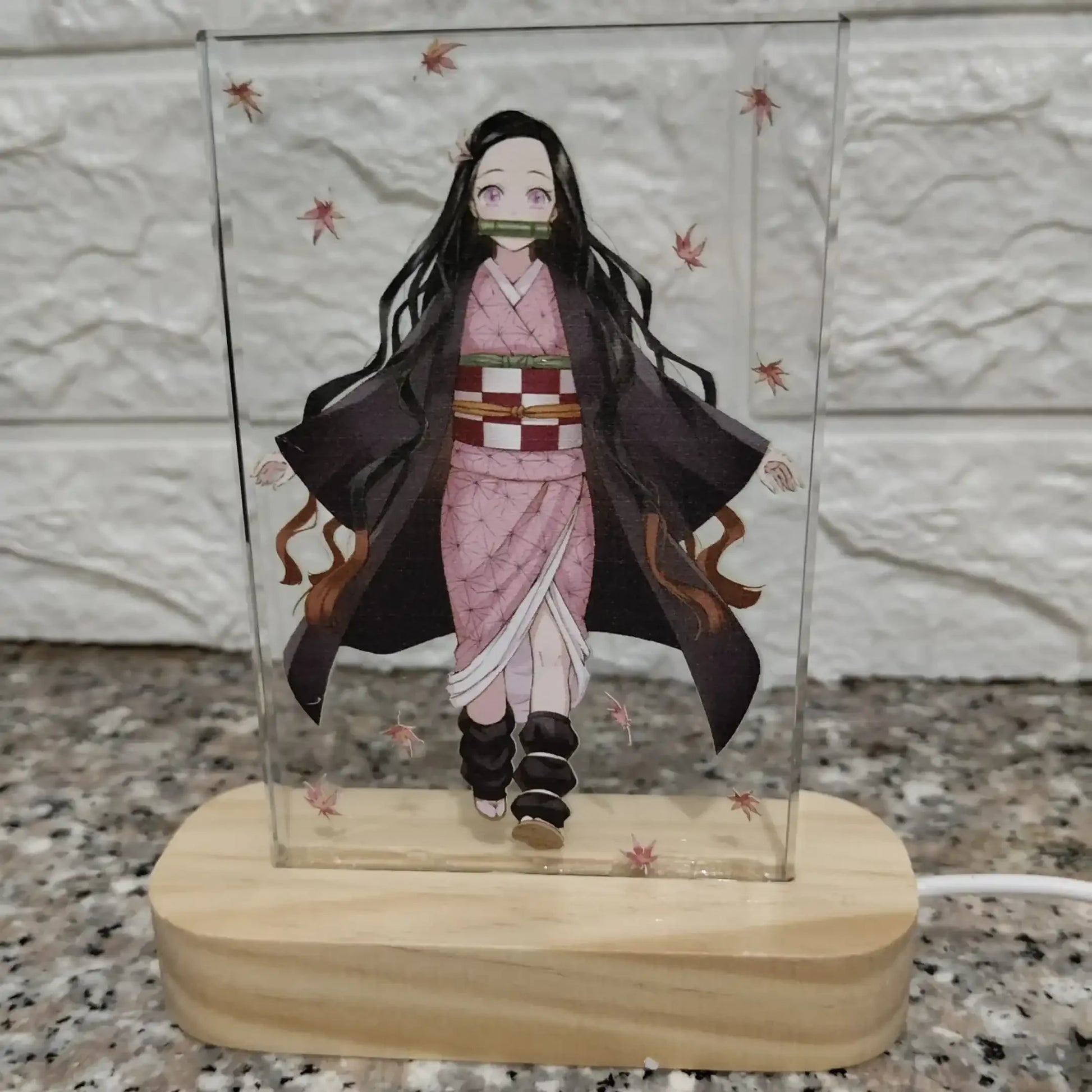 Figurine in a glass case on a wooden base with a stone wall background