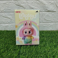 Cartoon character plush toy packaging on grass with a light gray brick wall background