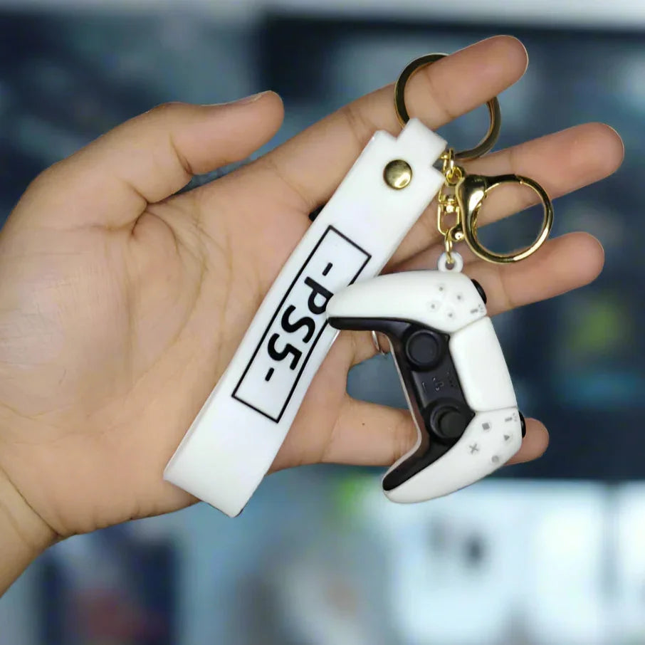 Hand holding a white keychain with a black trigger-like design against a textured gray wall.