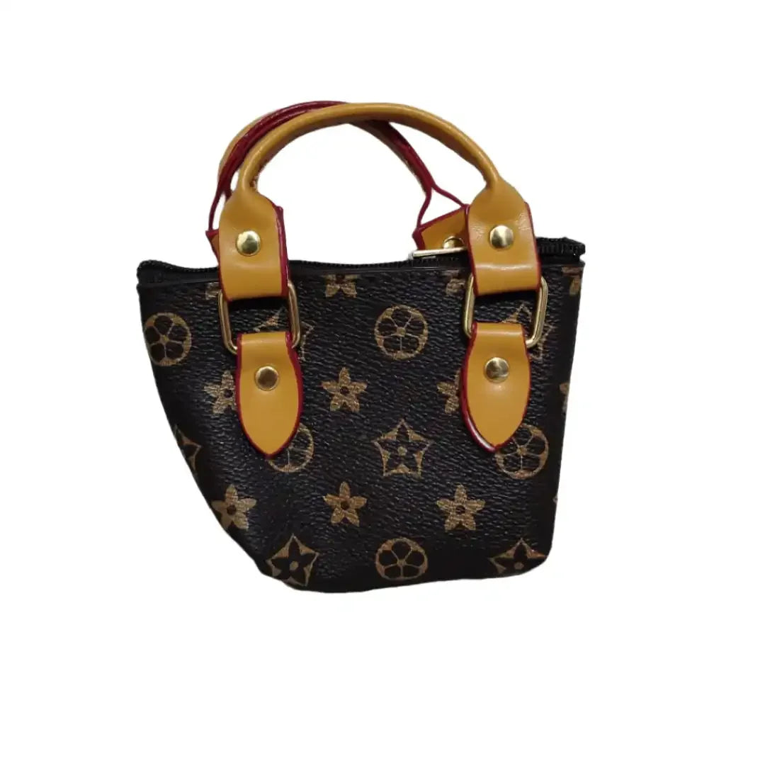 Small handbag with star pattern and brown handles on a marble surface.