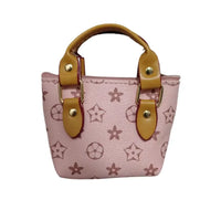 Pink handbag with star pattern and brown handles on a textured surface