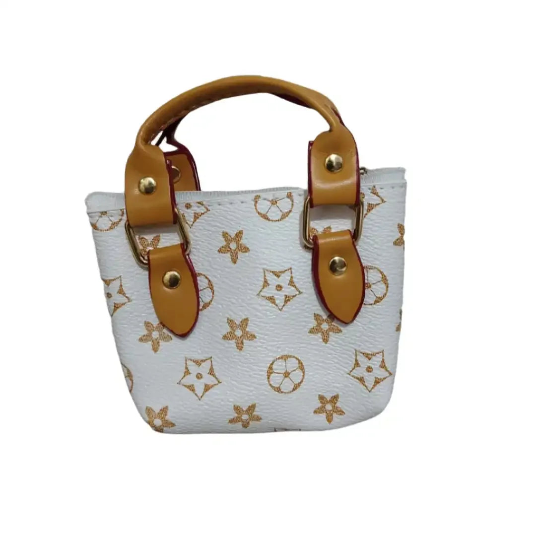 White handbag with brown handles and accents on a stone surface.