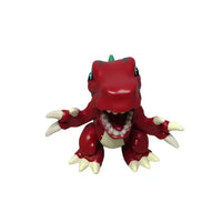 Red dinosaur toy figure on a gray surface with a white wall background