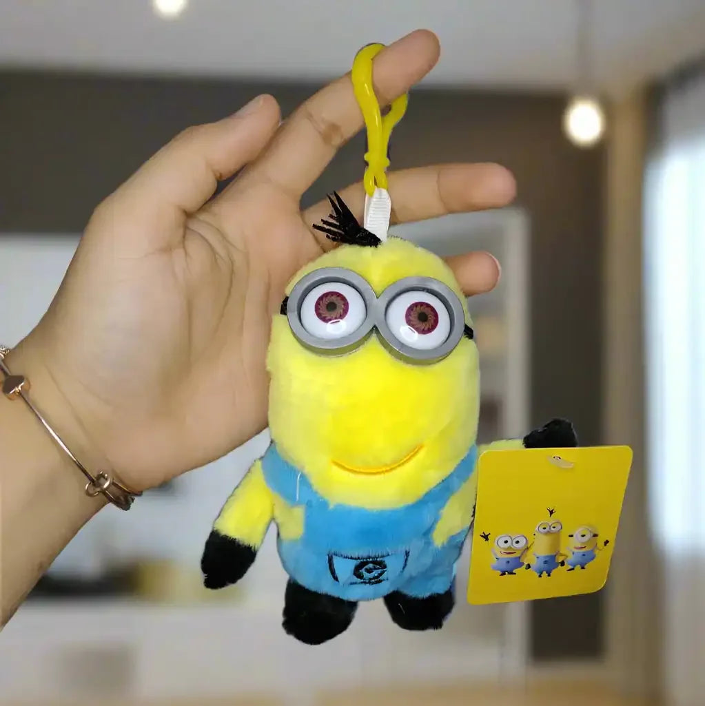 Plush toy keychain with a tag held by a hand against a neutral background