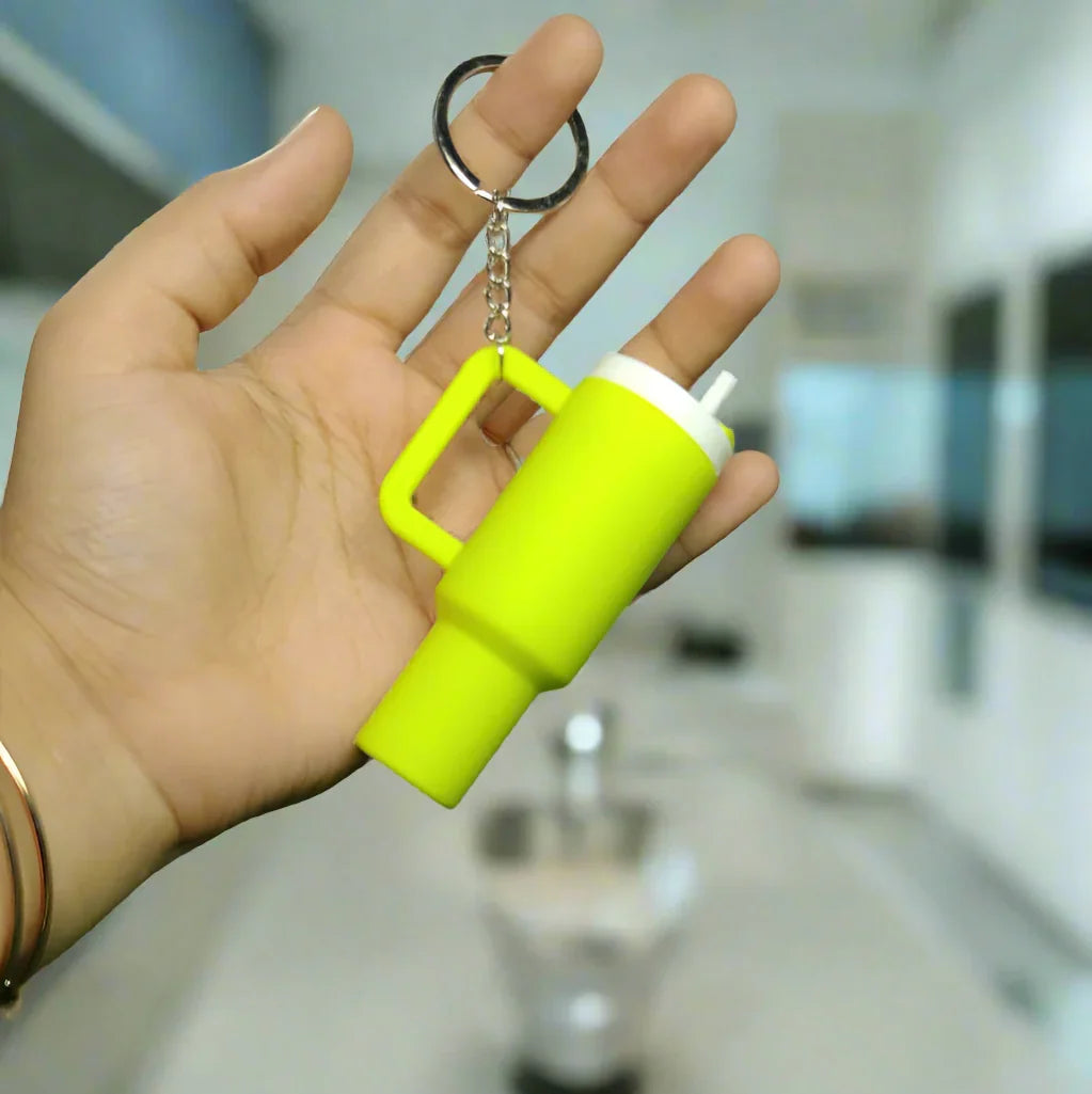 Hand holding a yellow stanley tumbler keychain