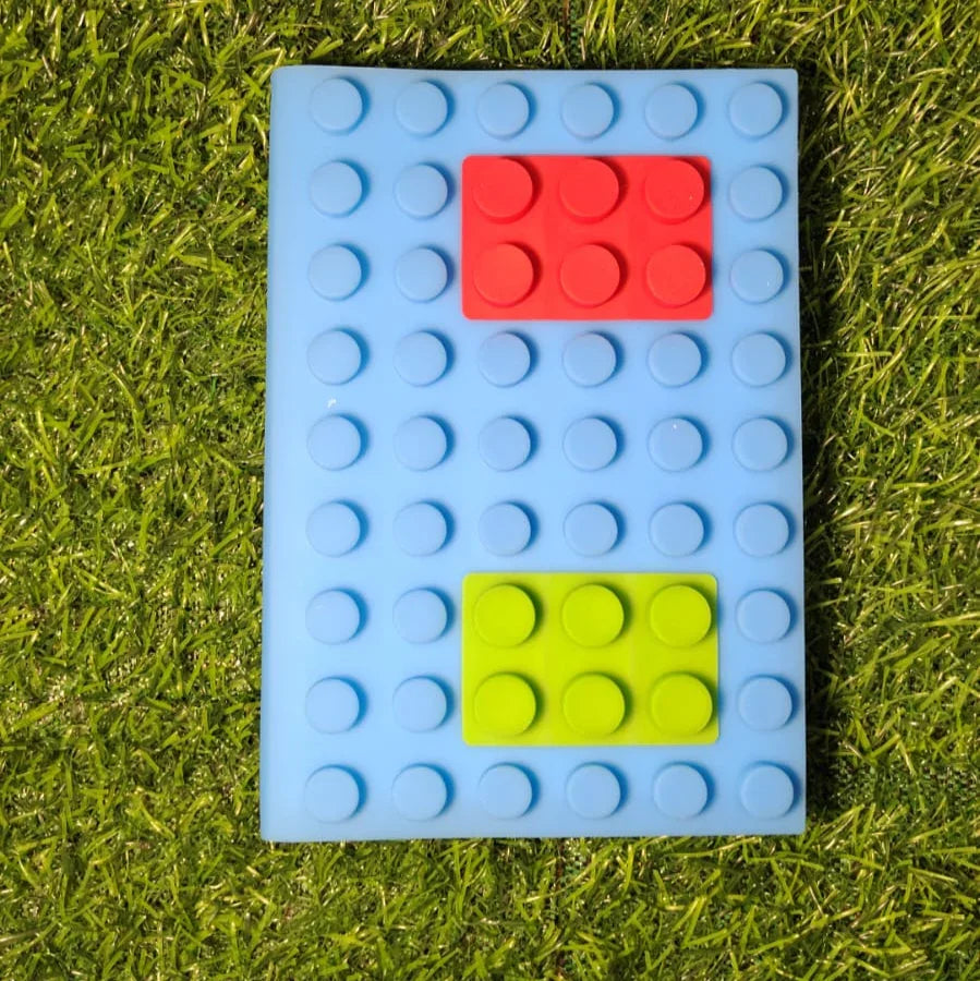 Blue building block with red and green shapes on grass