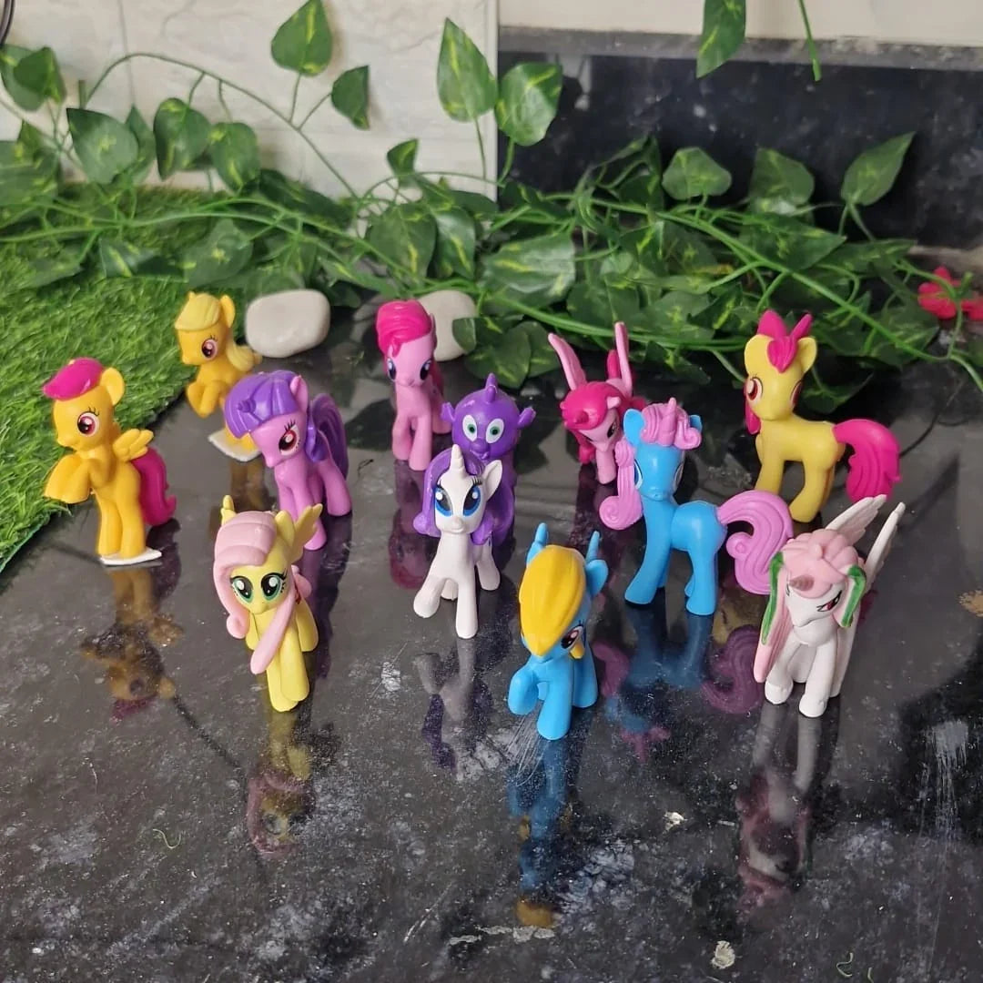 Colorful toy ponies on a reflective surface with greenery in the background