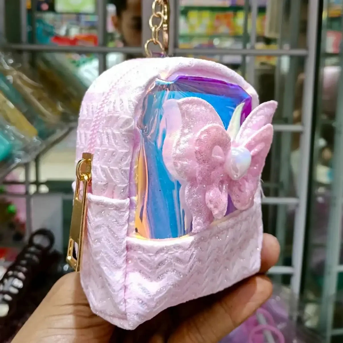 Pink butterfly-themed keychain case held in front of a store shelf.