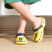 Yellow cartoon-style shoes worn by a person on a neutral background