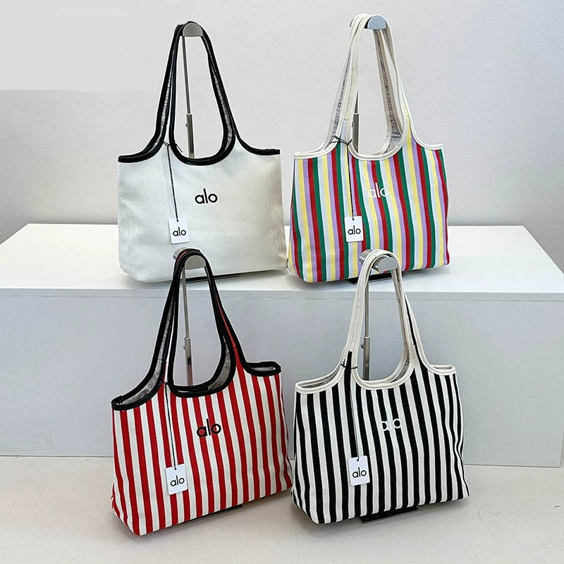 Four tote bags with different designs and colors on a white surface.