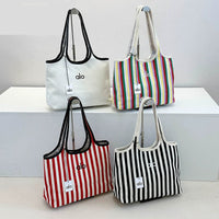 Four tote bags with different designs and colors on a white surface.