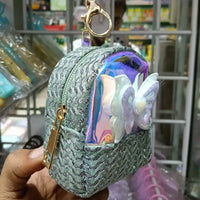Decorative keychain with butterfly design held by a hand in a store setting
