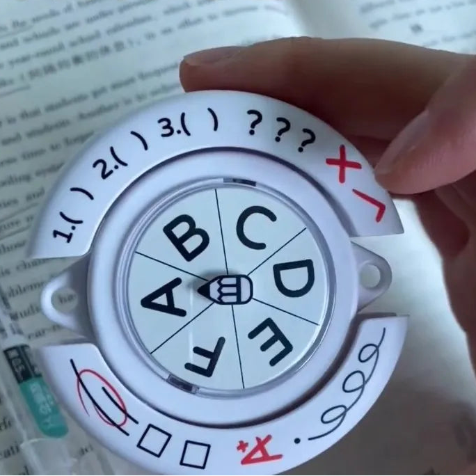 Hand holding a circular dial with letters and symbols, set against a blurred book background.