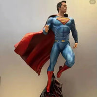 Superman figurine on a rocky base with a plain background
