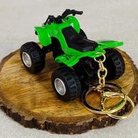 Green toy ATV on a wooden disc with gold keychain