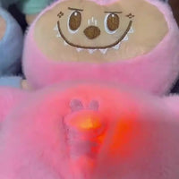 Pink plush toy with cartoon face and glowing red light on a dark background