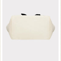 White pouch with black accents on a beige background, featuring the brand 'Peanuts'.