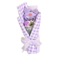 Bouquet with a plush toy and flowers wrapped in purple and white checkered paper on a white background