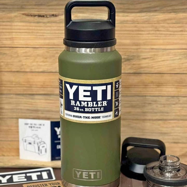 Green YETI Rambler bottle with black lid on a wooden surface