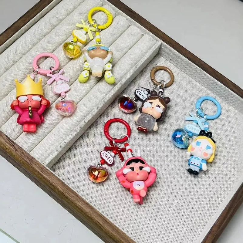 Set of colorful cartoon character keychains displayed on a textured surface.