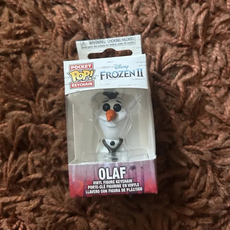 Packaged Disney Frozen II Olaf keychain on a brown textured surface