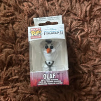 Packaged Disney Frozen II Olaf keychain on a brown textured surface