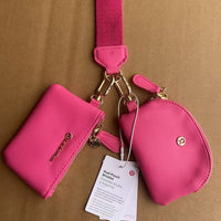 Pink wallet with strap and coin purse on a brown background