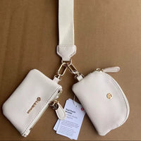 Two white pouches with a strap on a brown background