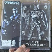 Action figure of T-800 from Terminator 2 in packaging held by a hand.