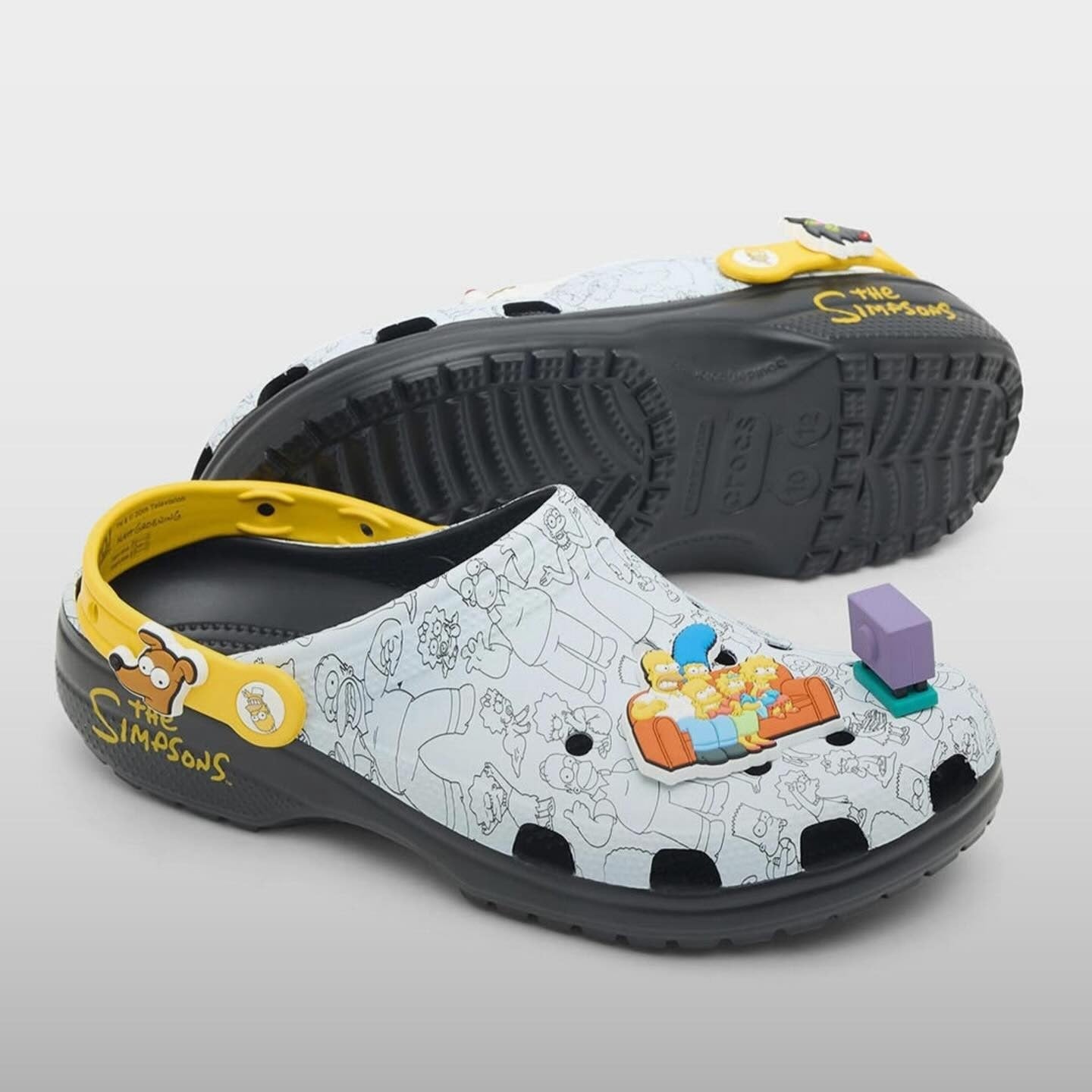 Pair of cartoon-themed clogs with colorful design on a gray background