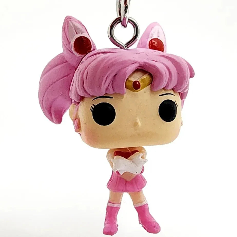 Pink-haired character keychain with a white heart on a white background