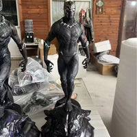 Black Panther statue on a table with a wooden wall background