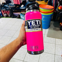 Pink YETI Rambler bottle held in a hand with a store in the background