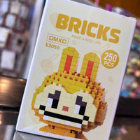Box of DMXC Bricks with a pixelated character design on a blurred background