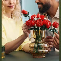 Two people holding red roses in a vase, with a blurred background.