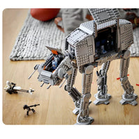 Toy AT-AT walker with figures on a wooden floor