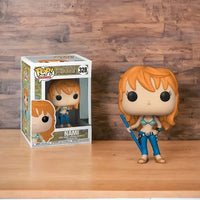 Funko Pop! vinyl figure of Nami from One Piece on a wooden surface with packaging.