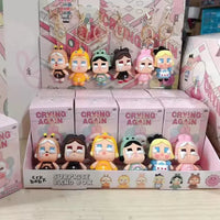 Collection of 'Crying Again' themed figurines in a display box with packaging.