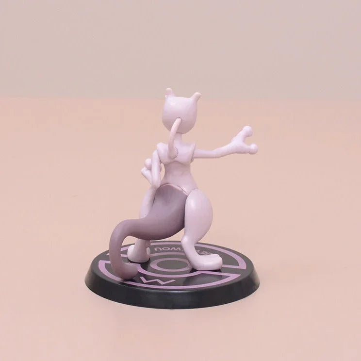White and pink cartoon character figurine on a black base with a pink background
