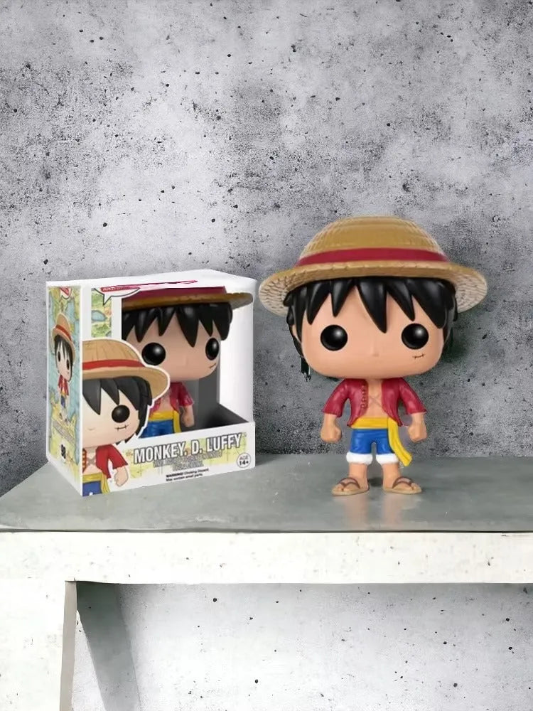 Funko Pop! figurine of Monkey D. Luffy next to its packaging on a gray surface.