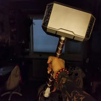 Hand holding a large hammer with a dark background