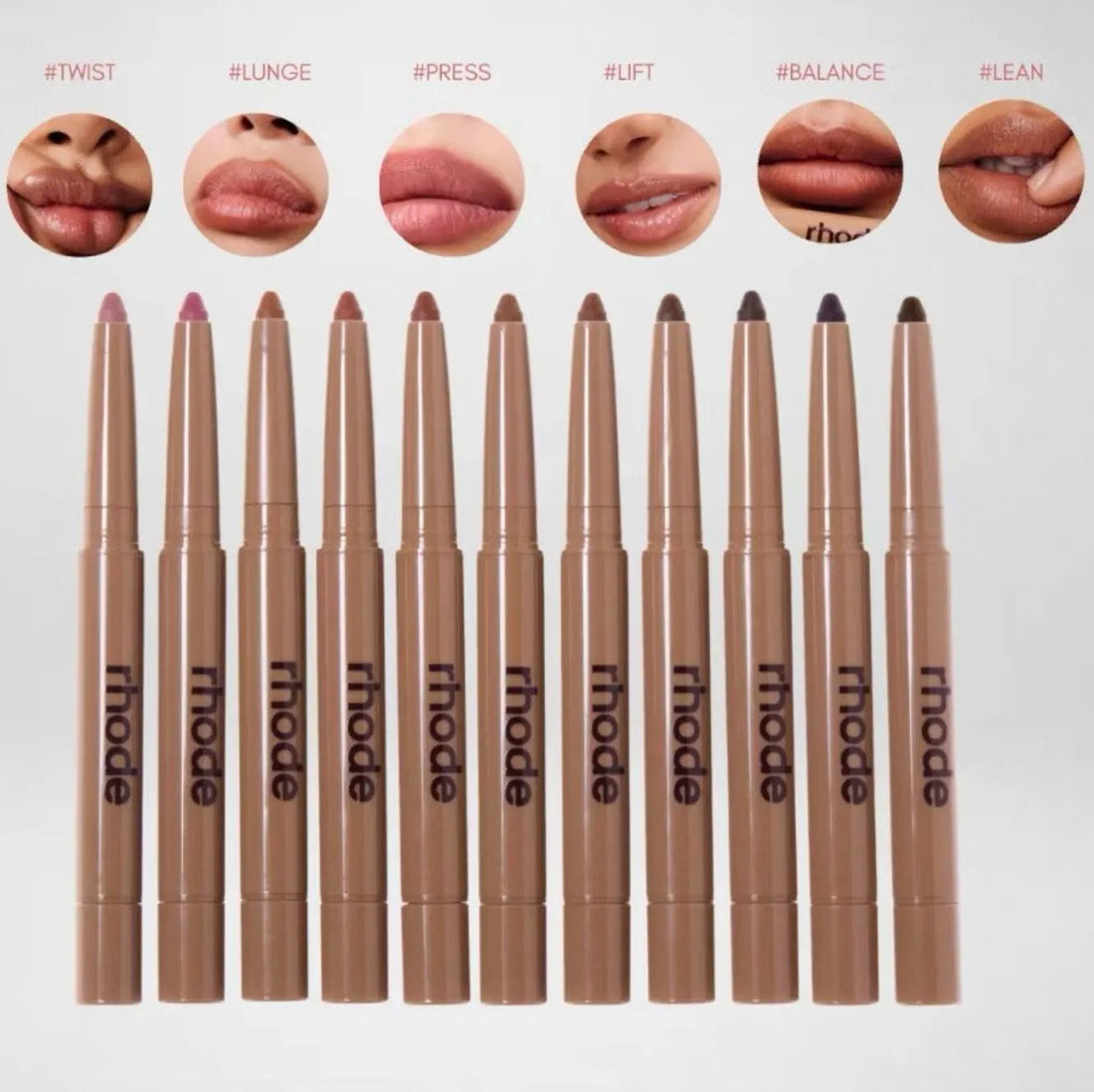Set of lip pencils with 'rhode' branding and sample lip swatches above them.