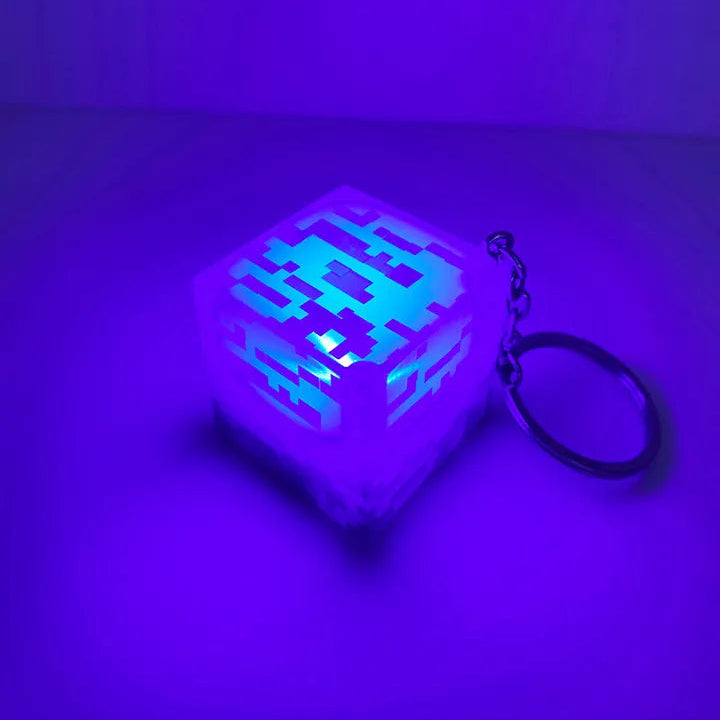 Cube-shaped keychain with pixelated design on a purple background