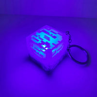 Cube-shaped keychain with pixelated design on a purple background