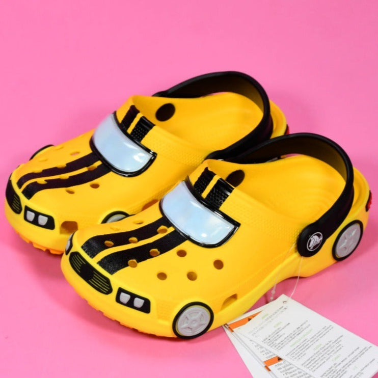 Yellow children's shoes with black stripes on a pink background