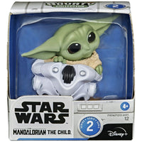 Star Wars figurine of The Child in packaging with branding and age rating.