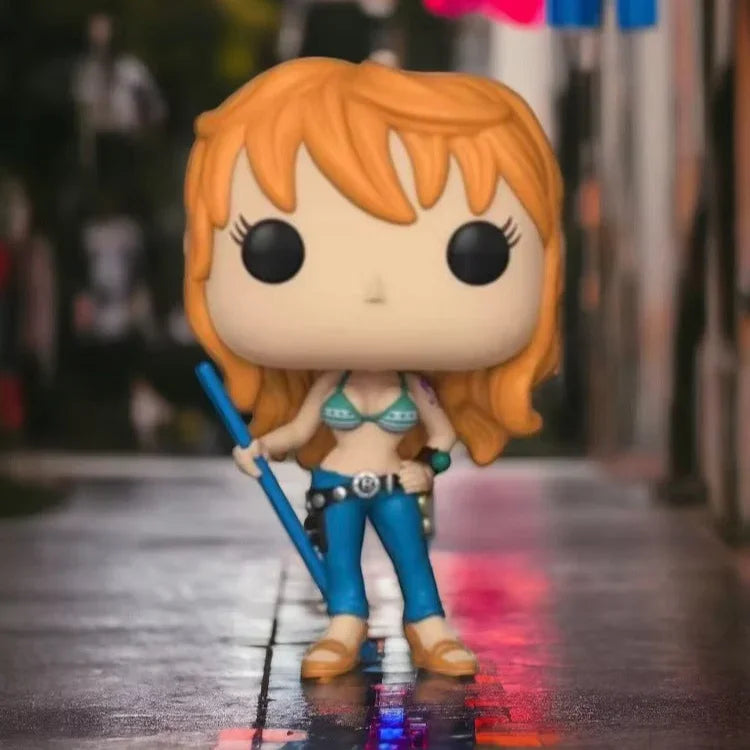 Funko Pop! vinyl figure of a character with orange hair and blue outfit holding a sword, standing on a wet street with colorful flags in the background.