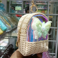 Small woven pouch with a butterfly design held in front of a store shelf.