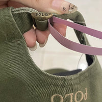 Green cap with 'POLO' branding held by a hand